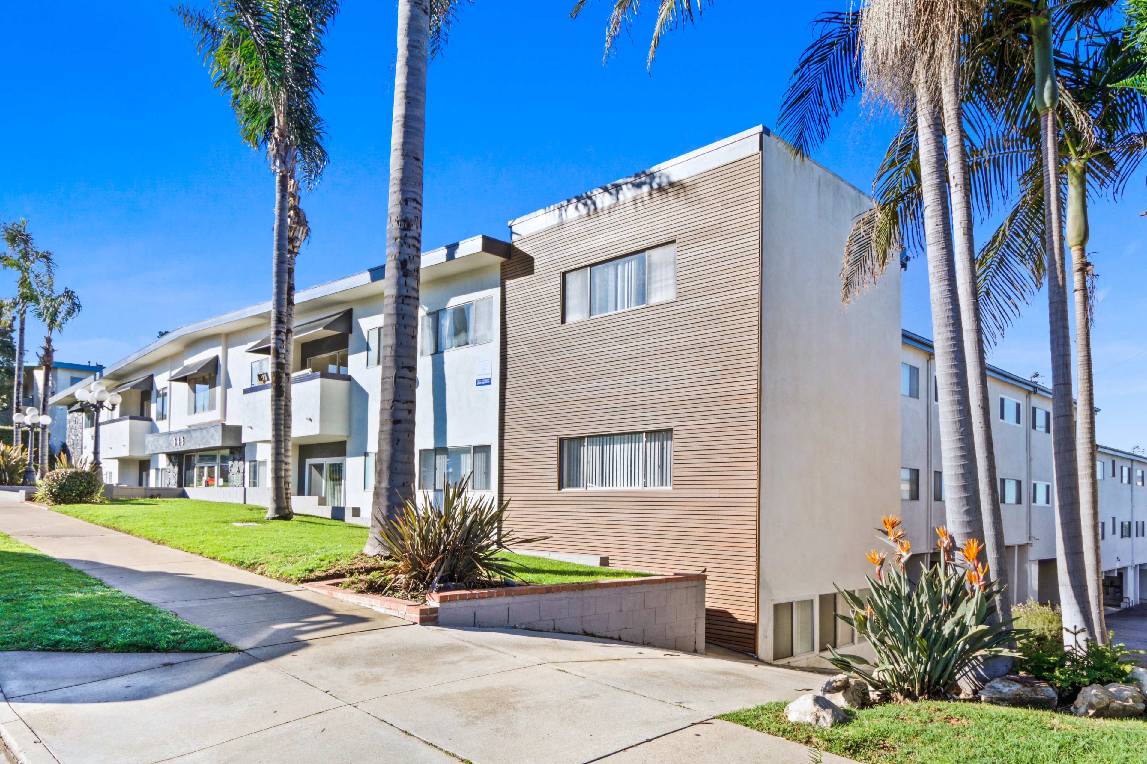 A modern apartment building with a clear blue sky above.