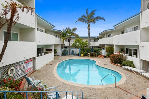 A pool in a courtyard surrounded by buildings.