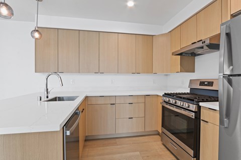 A modern kitchen with wooden cabinets and stainless steel appliances.