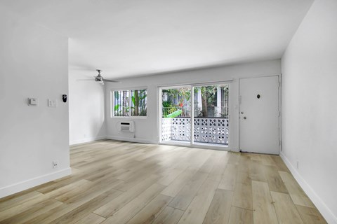 A room with wooden flooring and a ceiling fan.