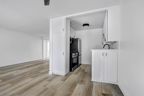 A kitchen with a white cabinet and a black oven.