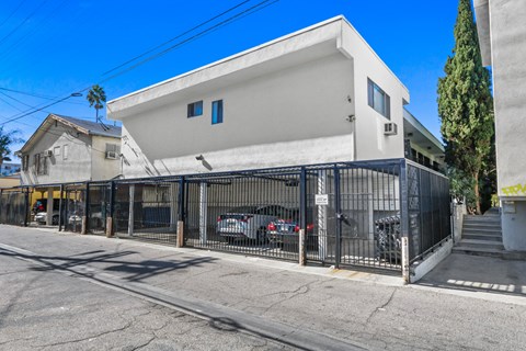 A white modern house with a black gate in front.