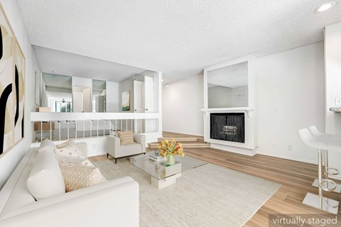 A living room with a white couch and a fireplace.