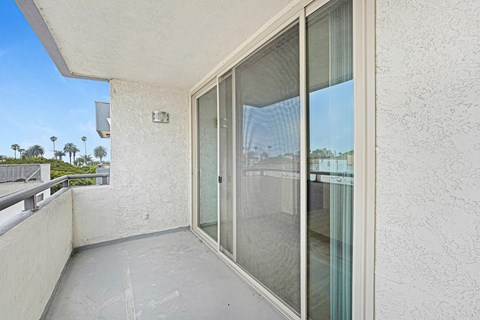 A balcony with a glass door and a railing.