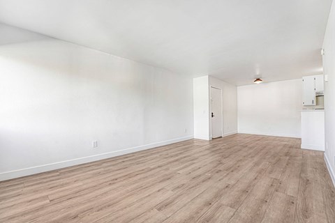 A room with wooden flooring and white walls.