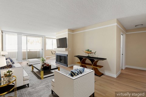 A living room with a white couch, a coffee table, and a television.