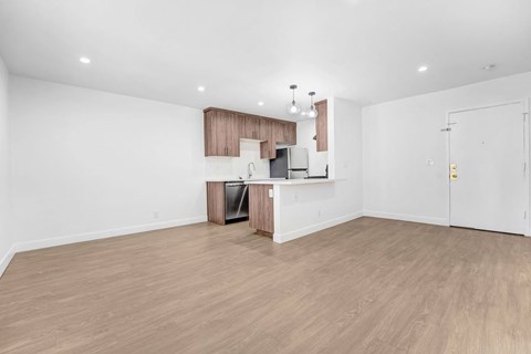 A kitchen area with a refrigerator, sink, and cabinets.
