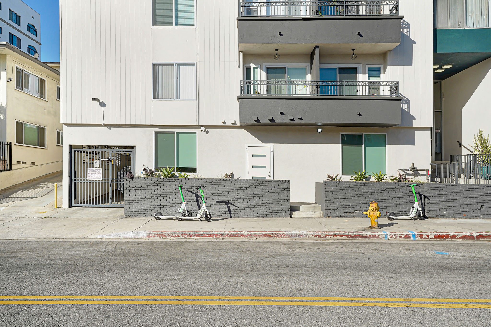 A white building with a yellow fire hydrant in front of it.