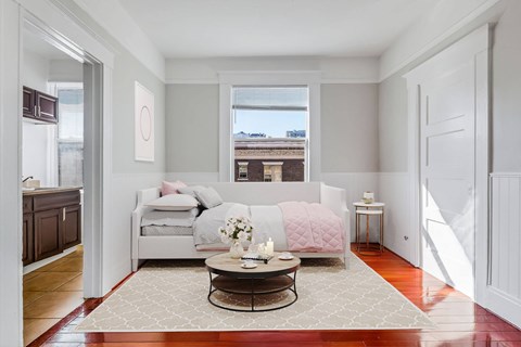 A living room with a couch, a coffee table, and a window.