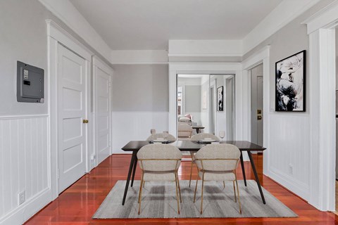 A dining room with a table set for four.