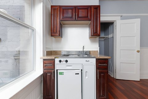A white dishwasher is in a kitchen with brown cabinets.