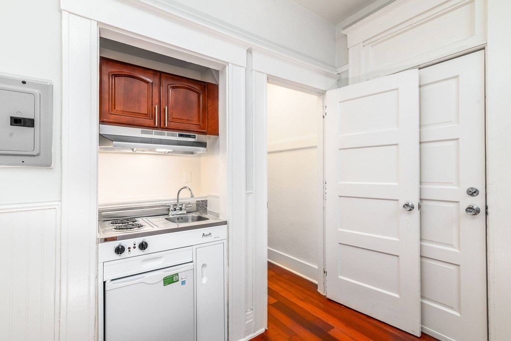 A small kitchen with a stove top oven and a dishwasher.