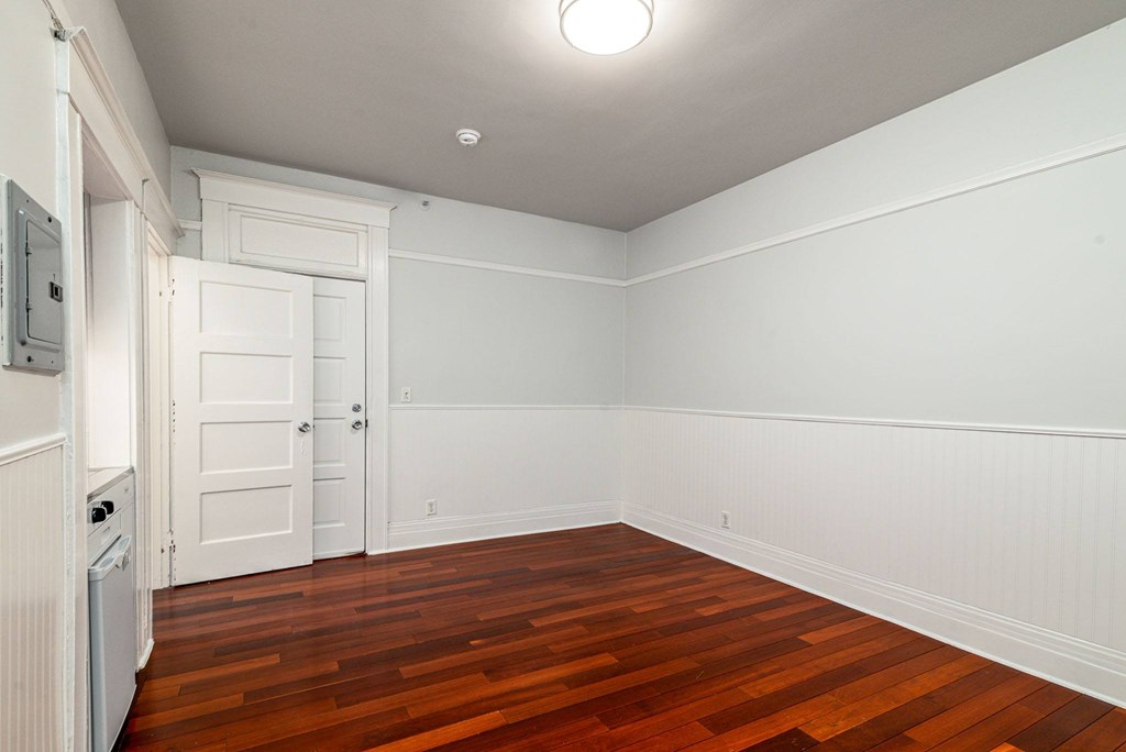 A room with white walls and a wooden floor.