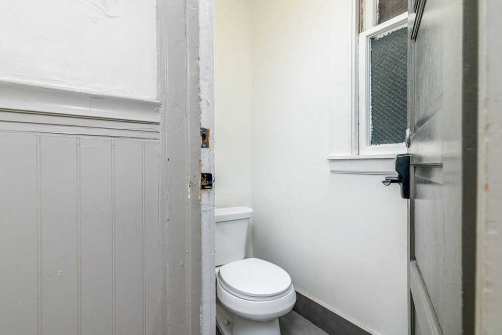 A white toilet in a bathroom with a white door.