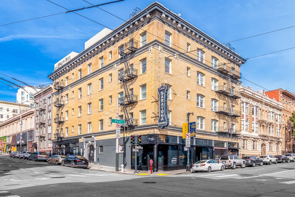 A street view of a city with a yellow building in the center.