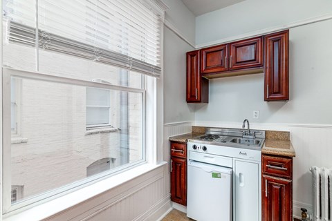 A kitchen with white appliances and wooden cabinets.