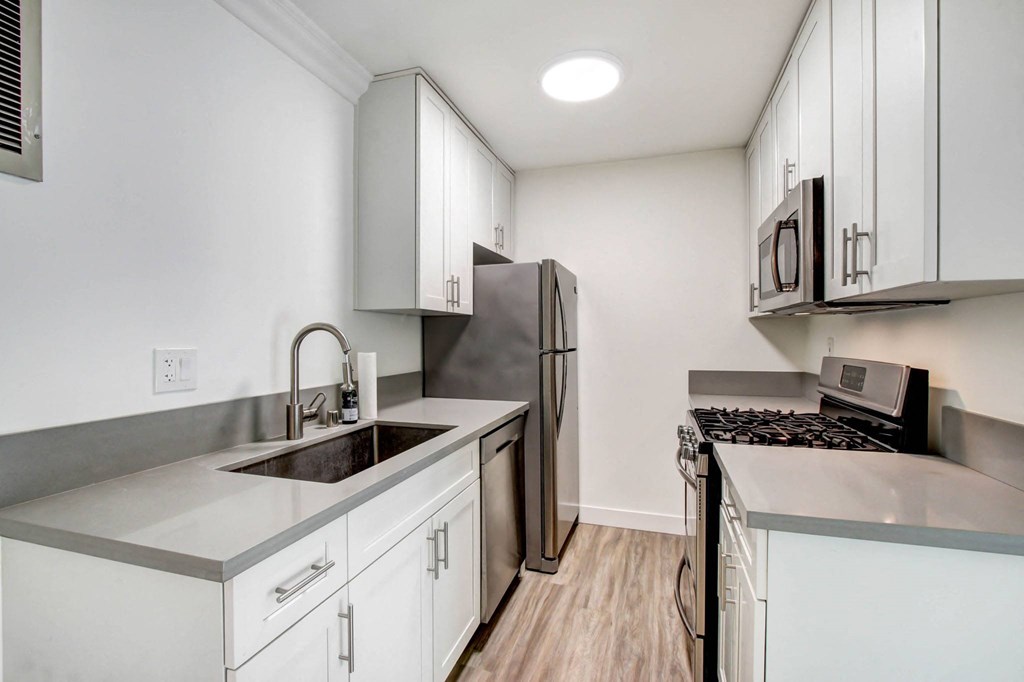a kitchen with white cabinets and a stainless steel refrigerator