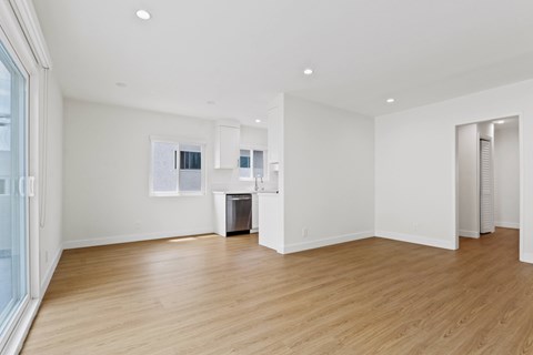 A spacious room with wooden floors and white walls.