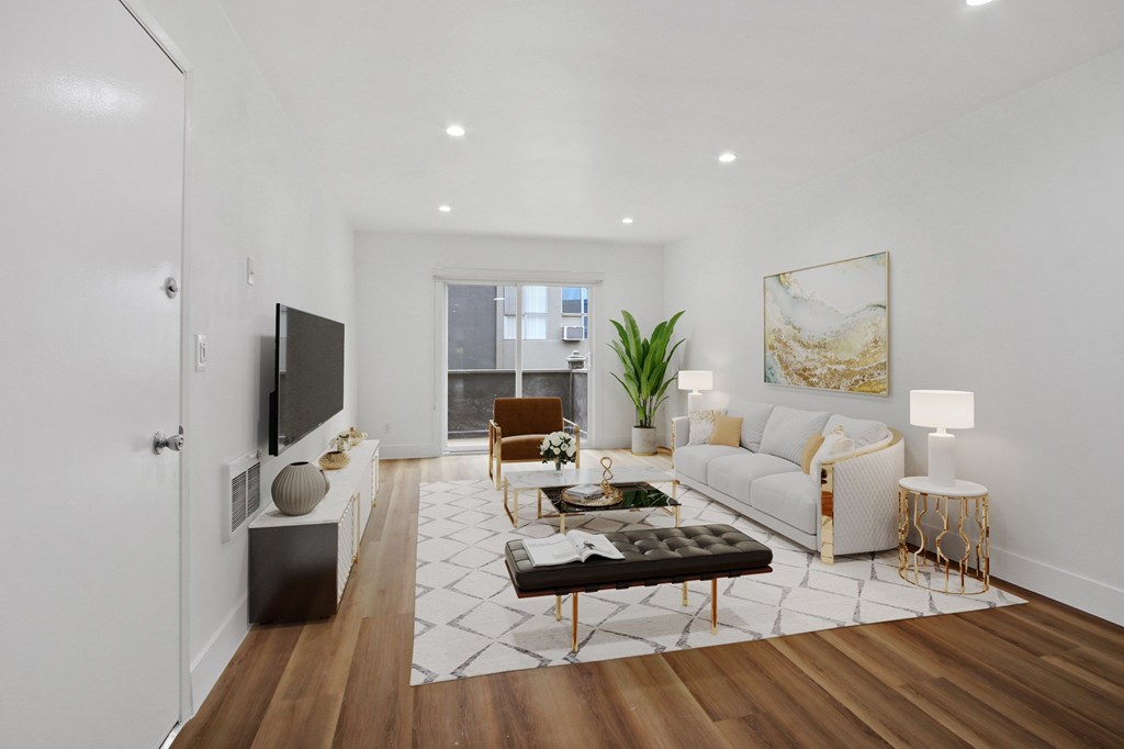 A modern living room with a white couch, a black coffee table, and a flat-screen TV.