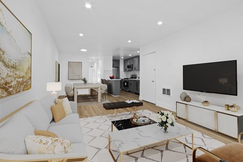 A modern living room with a white sofa, a coffee table, and a large painting on the wall.