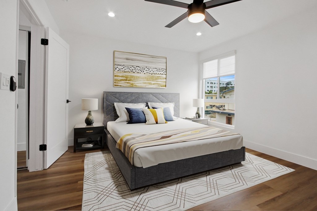 A bedroom with a large bed and a ceiling fan.
