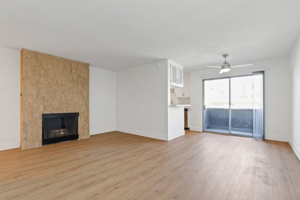 an empty living room with a fireplace and a sliding glass door