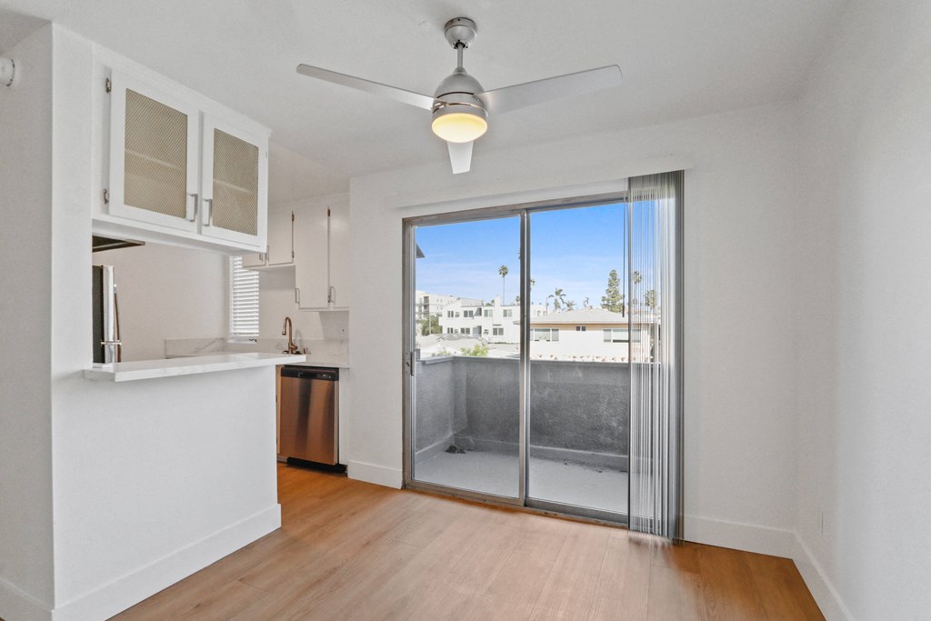 an empty living room with a sliding glass door to a balcony