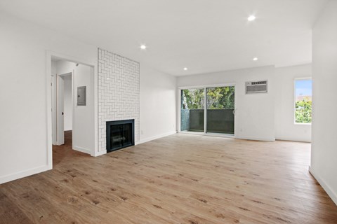 A room with a fireplace and wooden floors.