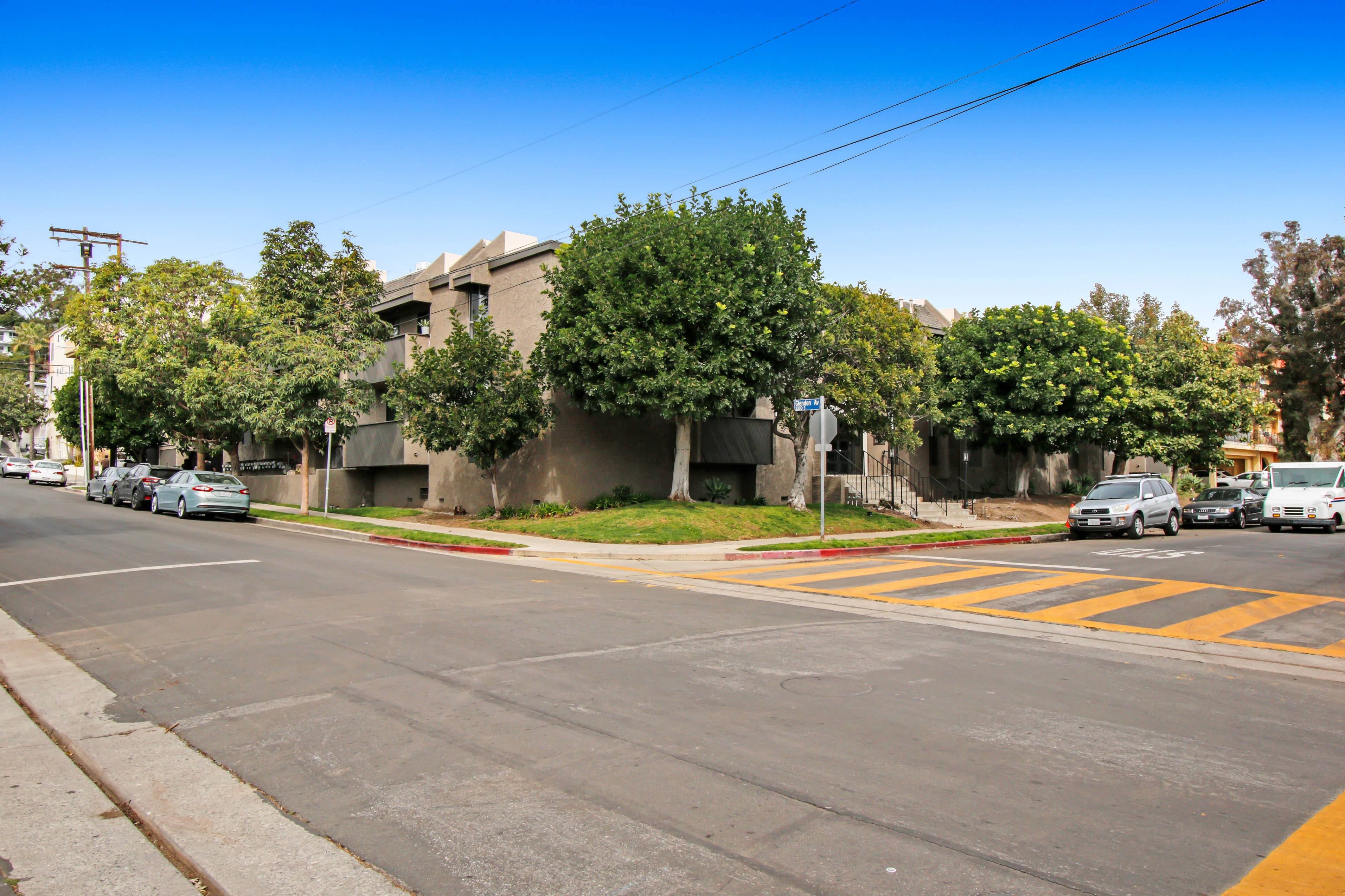 A street view with cars, trees, and buildings.