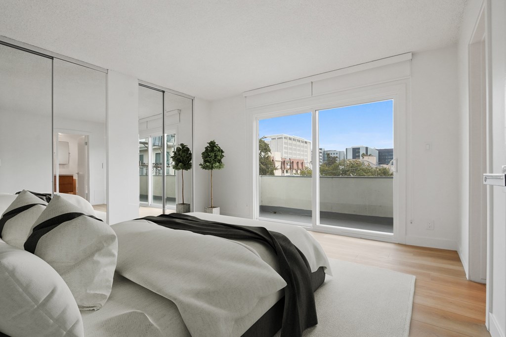 A bedroom with a large bed and a view of the city.