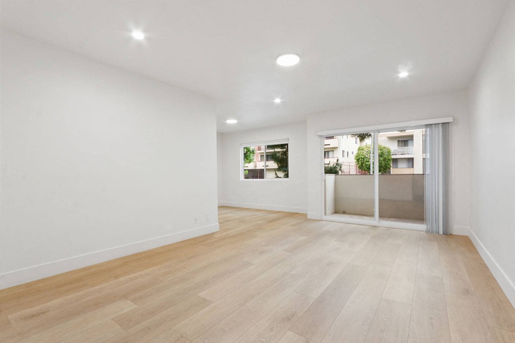 a living room with white walls and a sliding glass door