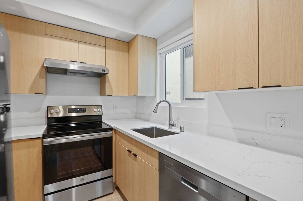 a kitchen with wooden cabinets and stainless steel appliances and a sink