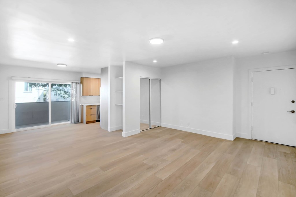 A room with wooden flooring and white walls.