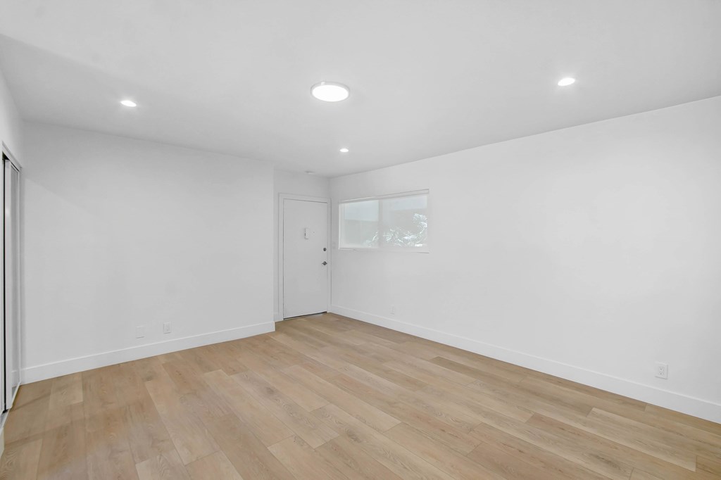 A room with wooden flooring and white walls.