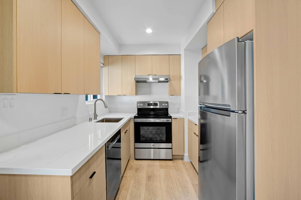 A modern kitchen with wooden cabinets and stainless steel appliances.