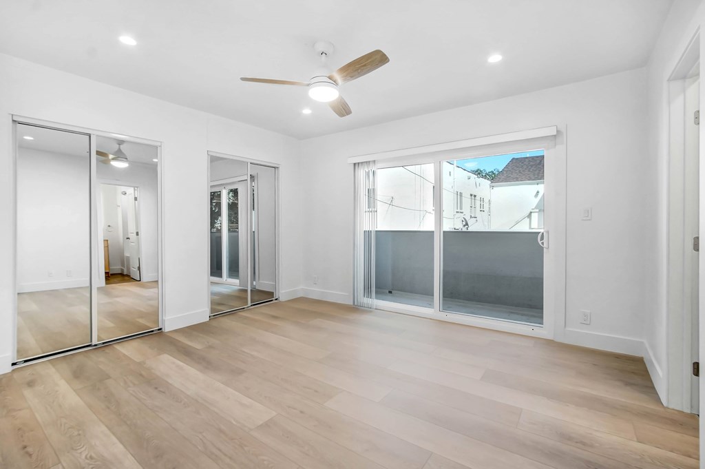 A spacious room with a ceiling fan and sliding glass doors.