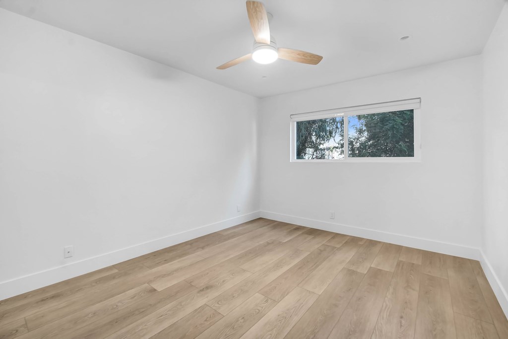 A room with a ceiling fan and a window.