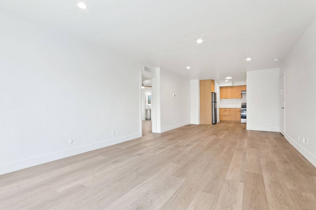 a living room with a hardwood floor and white walls