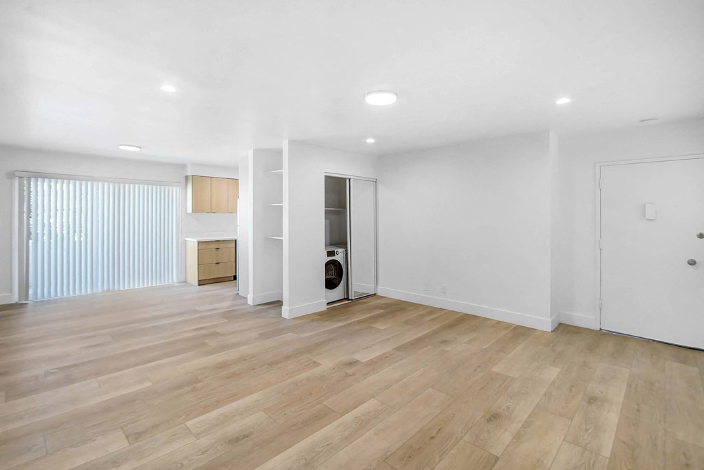 an empty living room with white walls and wood floors
