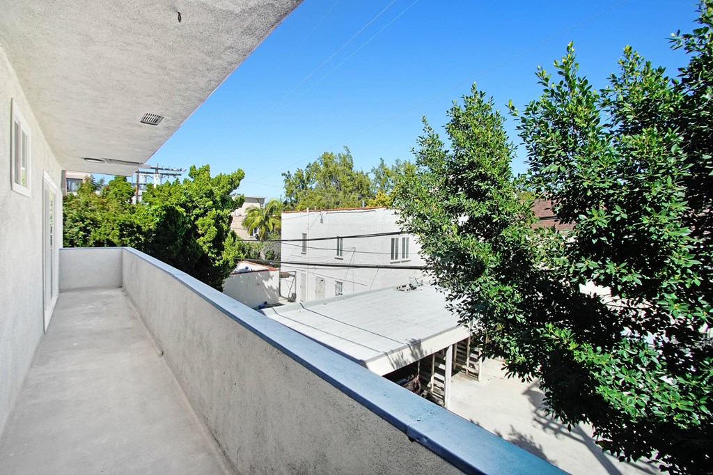 a long balcony with trees and a blue sky