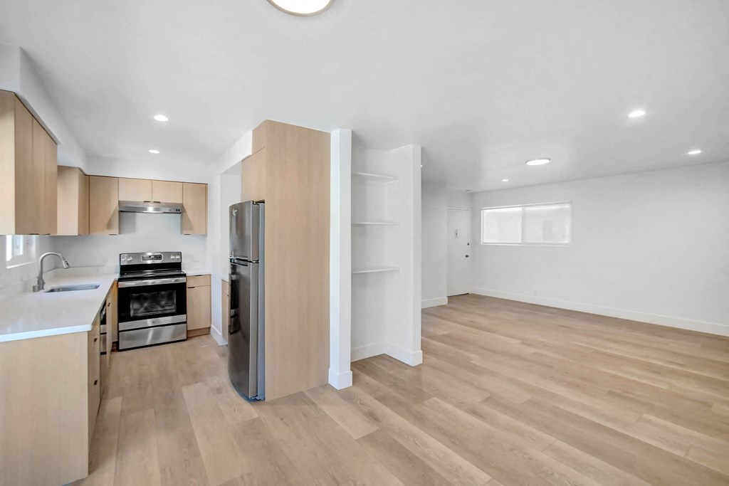 a renovated kitchen with wooden floors and white walls