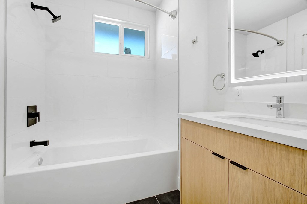 a bathroom with a tub and a sink and a window