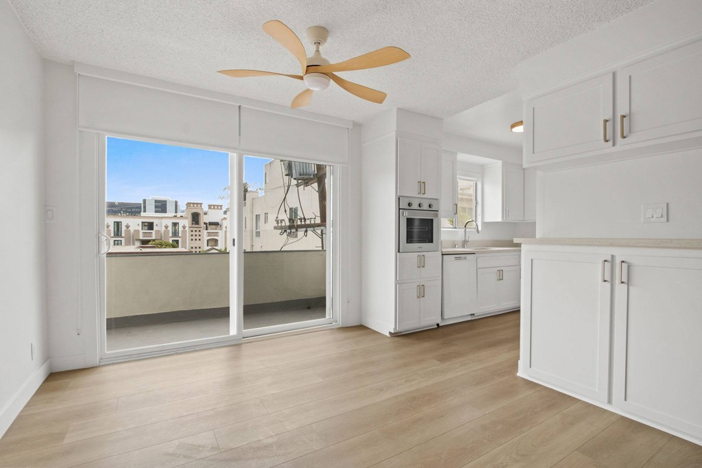A white kitchen with a fan and sliding glass doors.