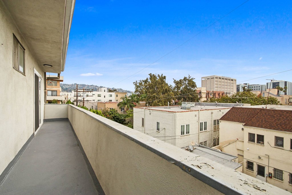 A long concrete balcony with a view of the city.
