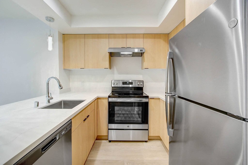 a kitchen with wooden cabinets and stainless steel appliances