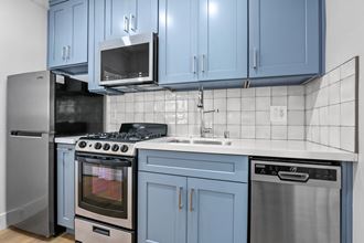 a kitchen with blue cabinets and appliances and a sink