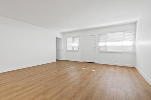 A room with wooden flooring and white walls.