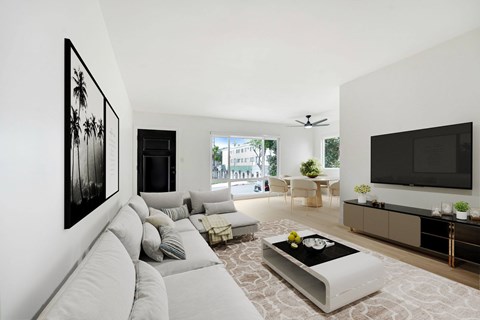 A living room with a grey sofa and a black and white painting on the wall.