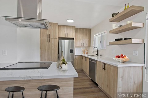 A modern kitchen with wooden cabinets and a marble countertop.