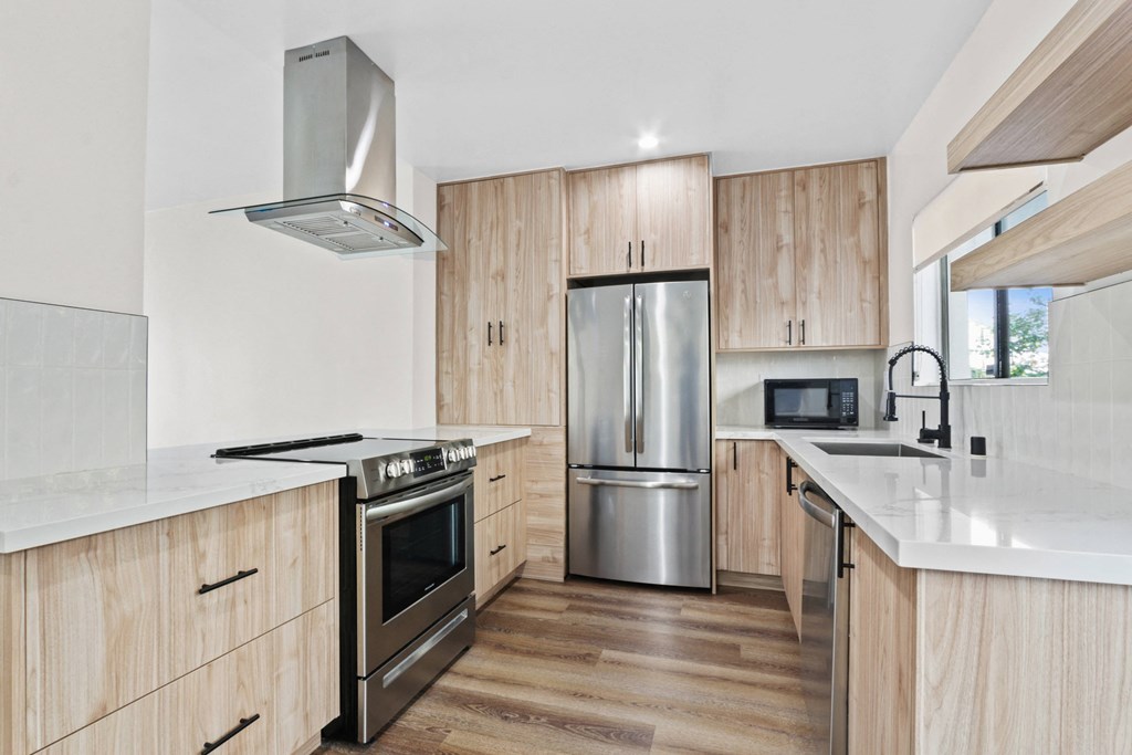 a kitchen with wooden cabinets and a stainless steel refrigerator